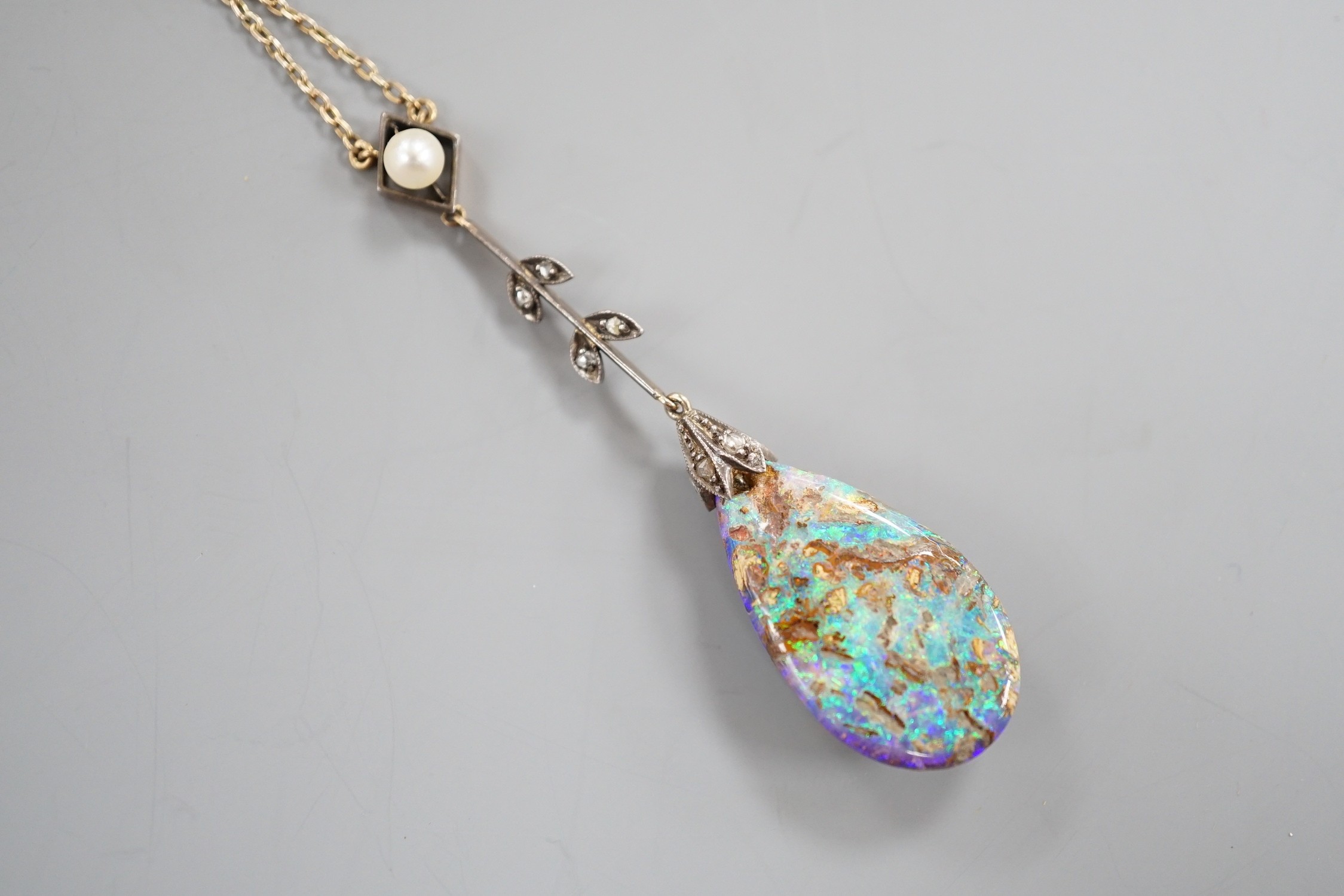 An early 20th century yellow and white metal, pear shaped black opal, rose cut diamond and seed pearl set drop pendant necklace, pendant overall 57mm, chain stamped 9ct, 37cm, gross weight 5.9 grams.